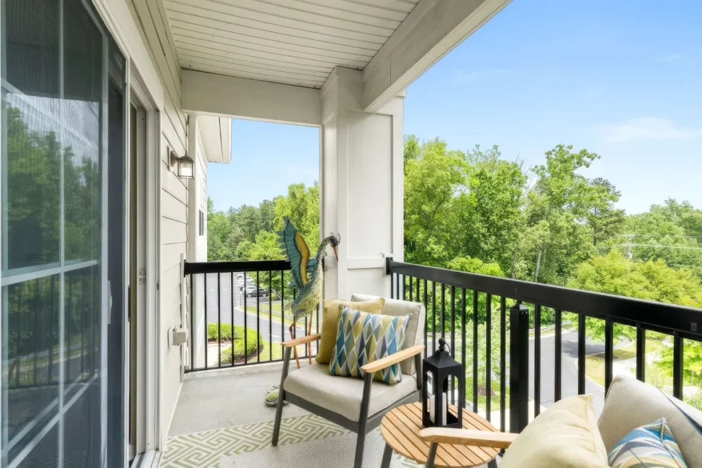 Balcony with a chair, a small table and a wooded view