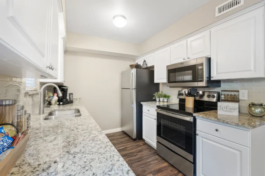 Kitchen with white cabinets, granite counters and stainless steel appliances