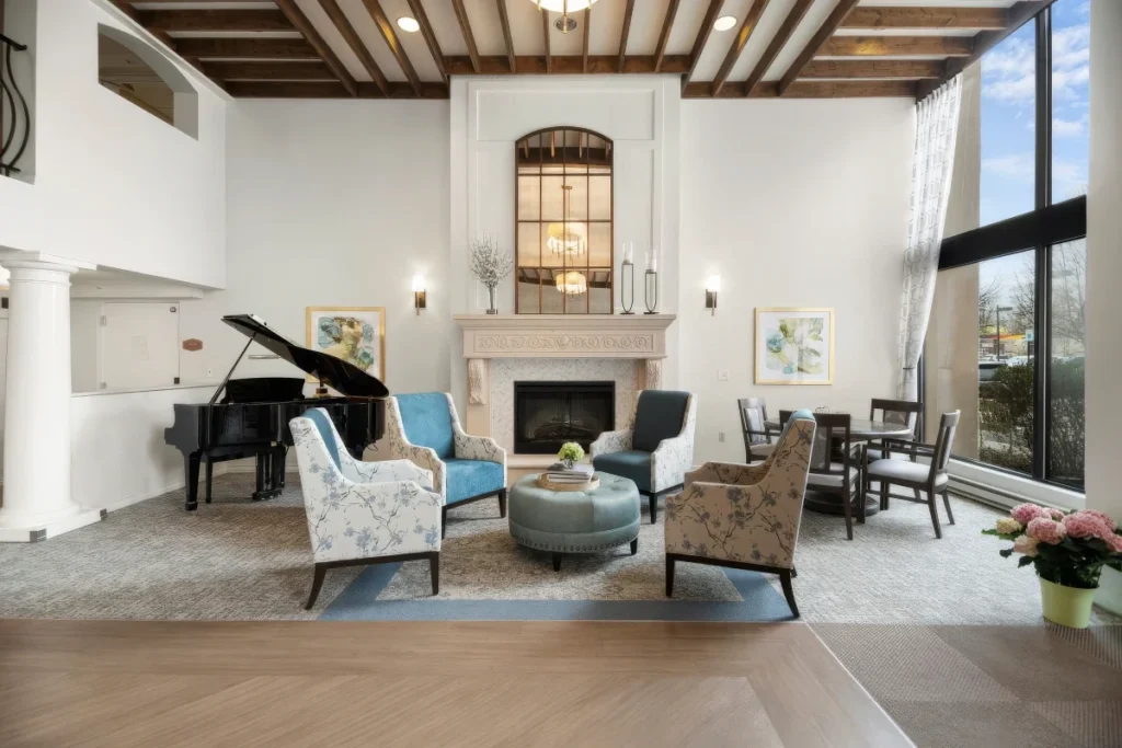 Lounge with a grand piano, a fireplace, armchairs and a high beamed ceiling