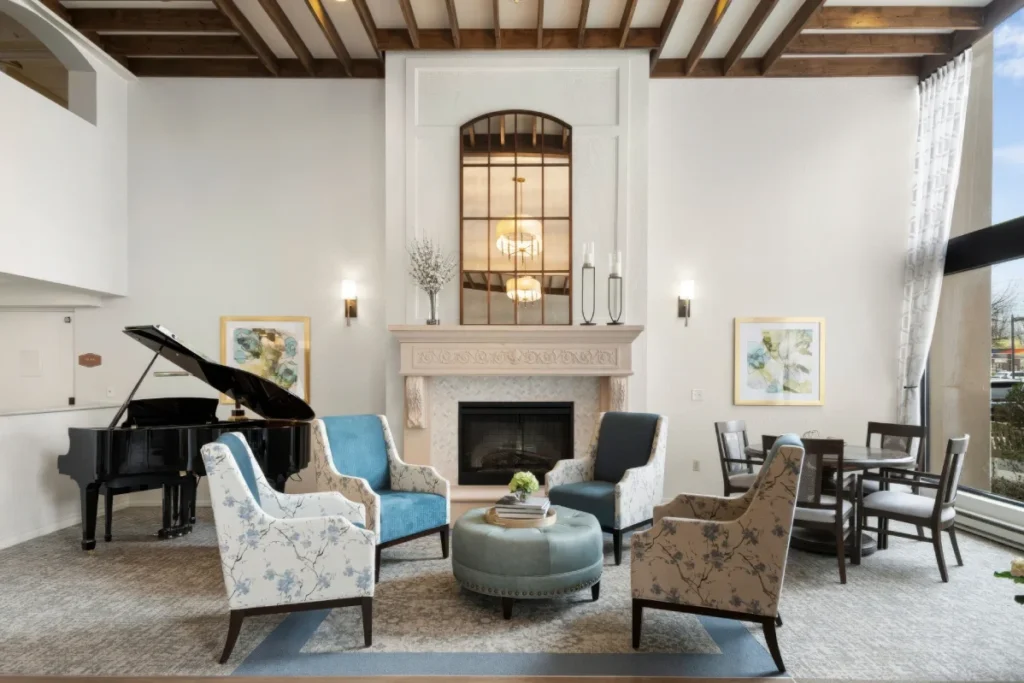 Lounge with a grand piano, a fireplace, armchairs and a high beamed ceiling