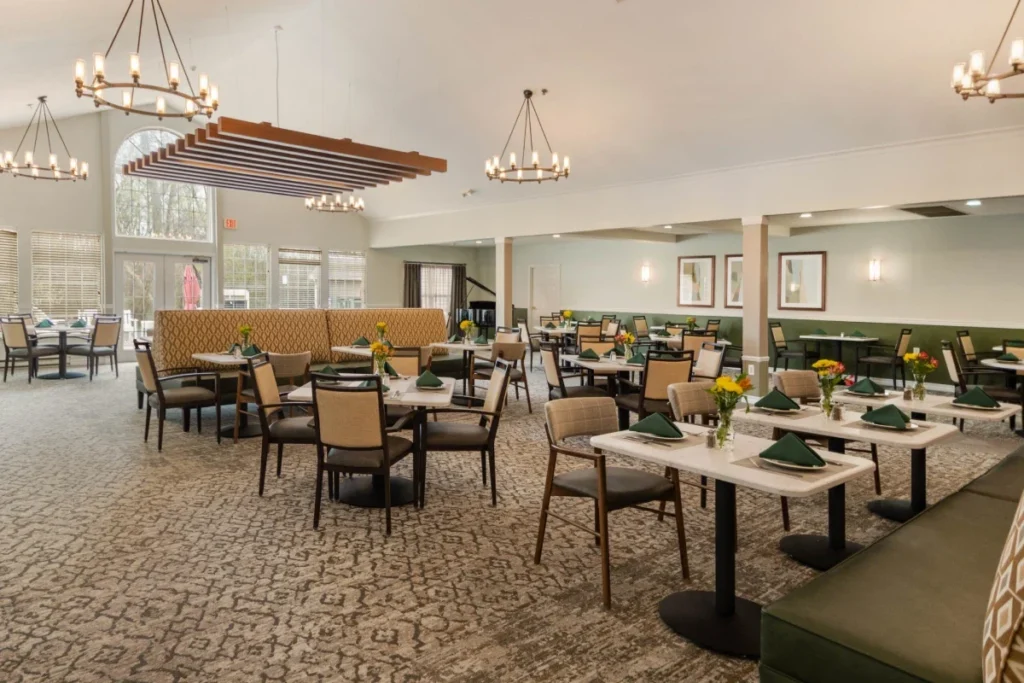 Dining room with square tables, booth seating and hanging chandeliers