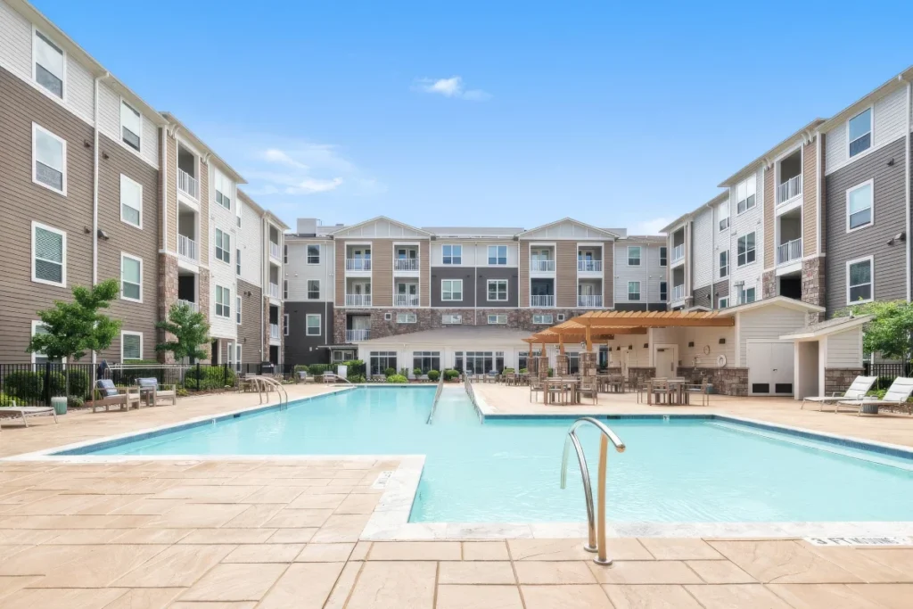 Courtyard swimming pool with a covered pavilion, surrounded by multi-story apartment buildings